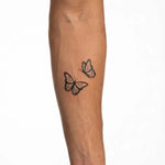 Tatuaggio semi-permanente INKON Butterfly Pair applicato su un uomo – design 2 x 2 in (5x5cm), aspetto realistico dell'inchiostro, dura 10 giorni