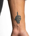 Tatuaggio semi-permanente INKON Skeleton Middle Finger applicato su un uomo – design 2 x 2 in (5x5cm), aspetto realistico dell'inchiostro, dura 10 giorni