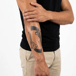 Tatuaggio semi-permanente INKON Doppie Rivoltelle applicato su un uomo – design 4 x 7 in (10x17cm), aspetto realistico dell'inchiostro, dura 10 giorni