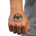 Tatuaggio semi-permanente INKON Bat Signal applicato su un uomo – design 2 x 2 in (5x5cm), aspetto realistico dell'inchiostro, dura 10 giorni
