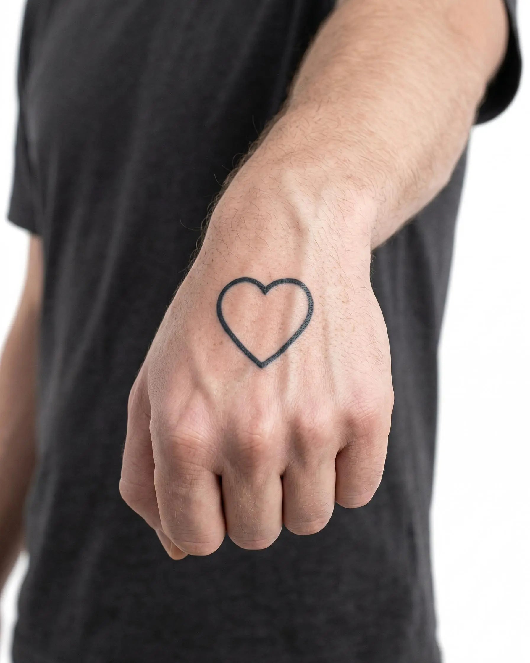 Tatuaggio semi-permanente INKON Heart Outline applicato su un uomo – design 2 x 2 in (5x5cm), aspetto realistico dell'inchiostro, dura 10 giorni