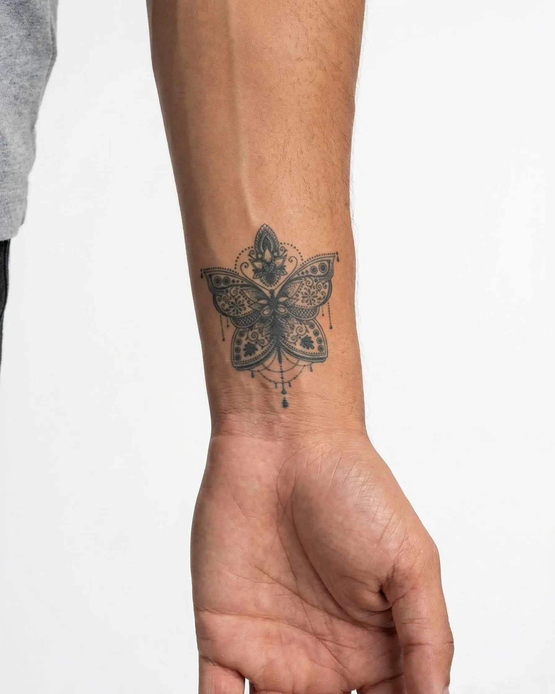 Tatuaggio semi-permanente INKON Ornamental Butterfly applicato su un uomo – design 2 x 2 in (5x5cm), aspetto realistico dell'inchiostro, dura 10 giorni