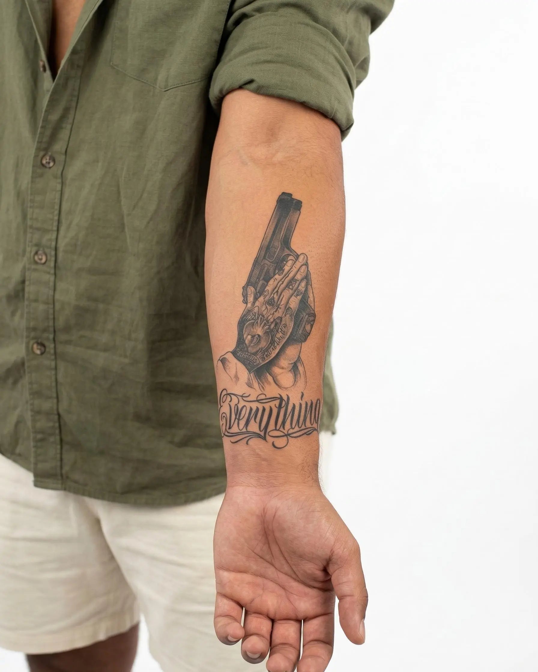 Tatuaggio semi-permanente INKON Mani in Preghiera e Pistola applicato su un uomo – design 4 x 7 in (10x17cm), aspetto realistico dell'inchiostro, dura 10 giorni