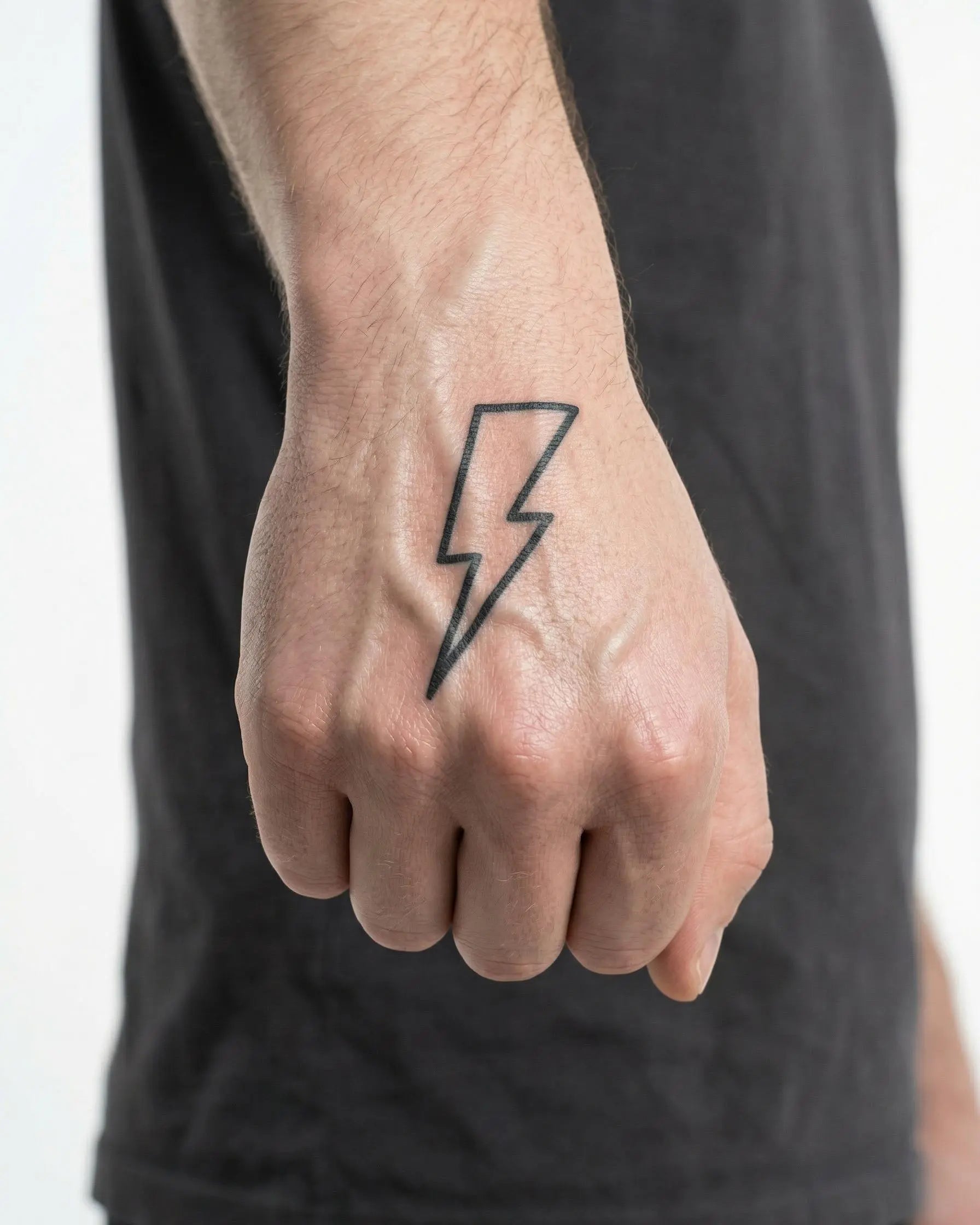 Tatuaggio semi-permanente INKON Lightning Bolt 2 applicato su un uomo – design 2 x 2 in (5x5cm), aspetto realistico dell'inchiostro, dura 10 giorni