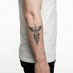 Tatuaggio semi-permanente INKON Caduceus Serpents & Sword applicato su un uomo – design 3 x 4 in (7x10cm), aspetto realistico dell'inchiostro, dura 10 giorni