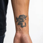 Tatuaggio semi-permanente INKON Twin Dragons applicato su un uomo – design 2 x 2 in (5x5cm), aspetto realistico dell'inchiostro, dura 10 giorni