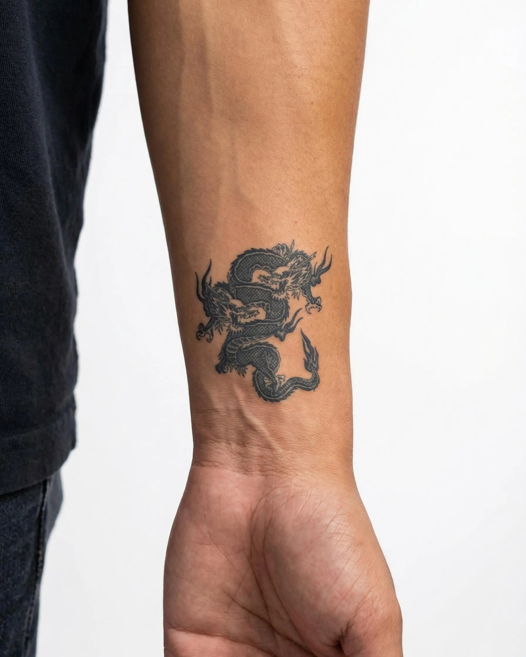 Tatuaggio semi-permanente INKON Twin Dragons applicato su un uomo – design 2 x 2 in (5x5cm), aspetto realistico dell'inchiostro, dura 10 giorni