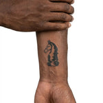 Tatuaggio semi-permanente INKON Engraved Chess Knight applicato su un uomo – design 2 x 2 in (5x5cm), aspetto realistico dell'inchiostro, dura 10 giorni