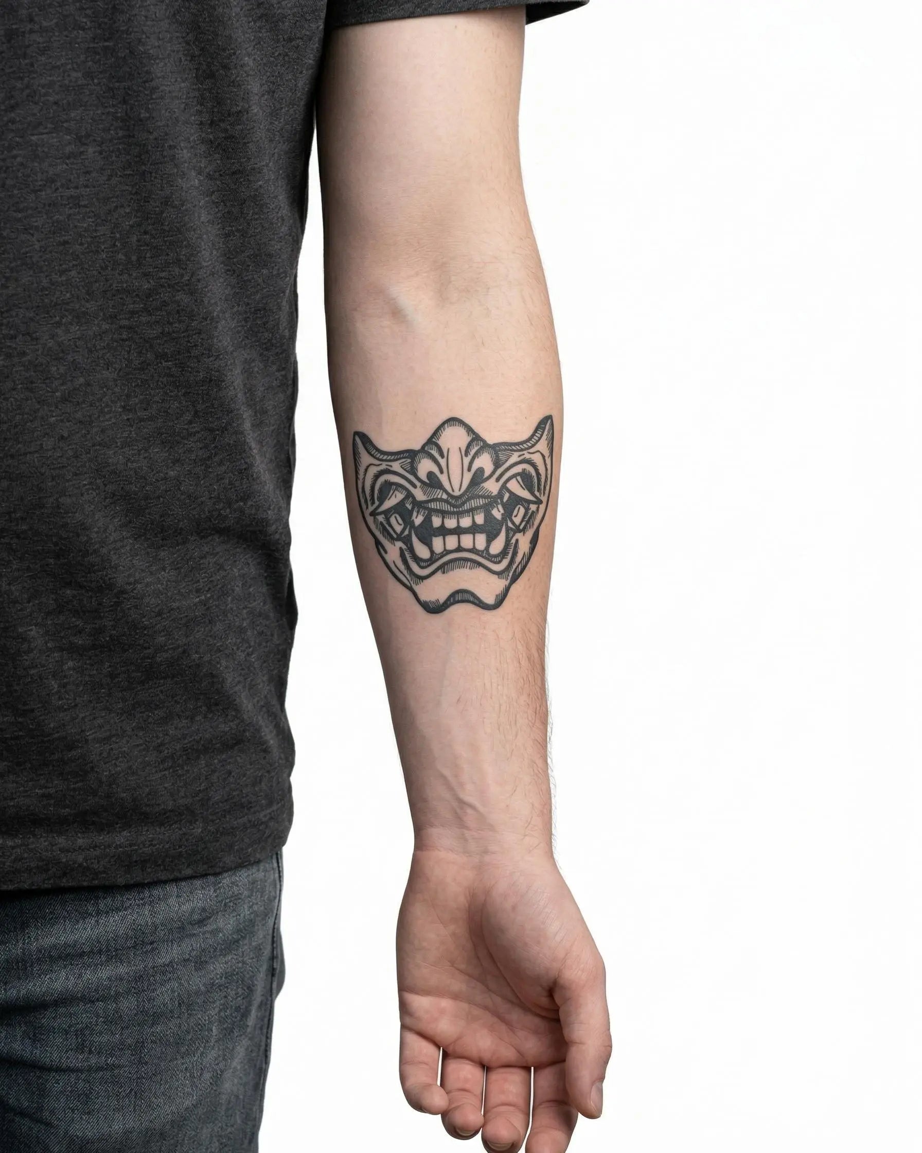 Tatuaggio semi-permanente INKON Maschera Oni applicato su un uomo – design 4 x 4 in (9x9cm), aspetto realistico dell'inchiostro, dura 10 giorni