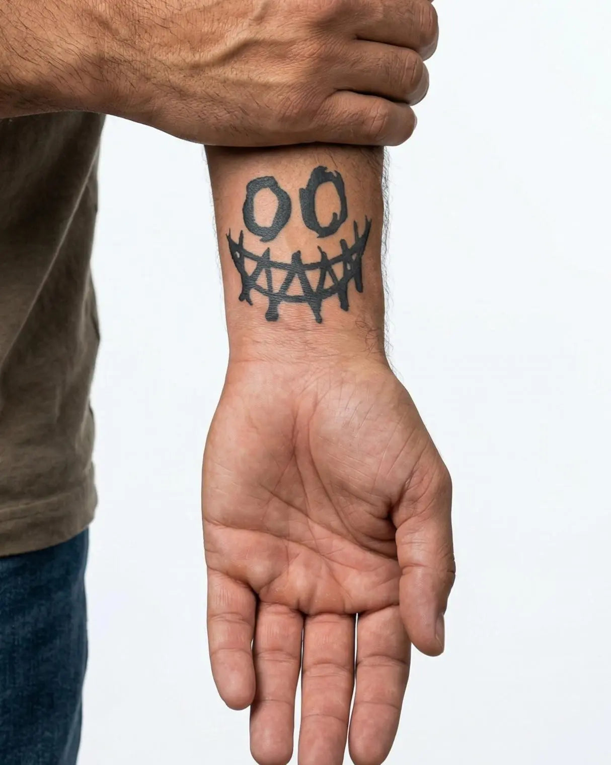 Tatuaggio semi-permanente INKON Creepy Smile applicato su un uomo – design 2 x 2 in (5x5cm), aspetto realistico dell'inchiostro, dura 10 giorni