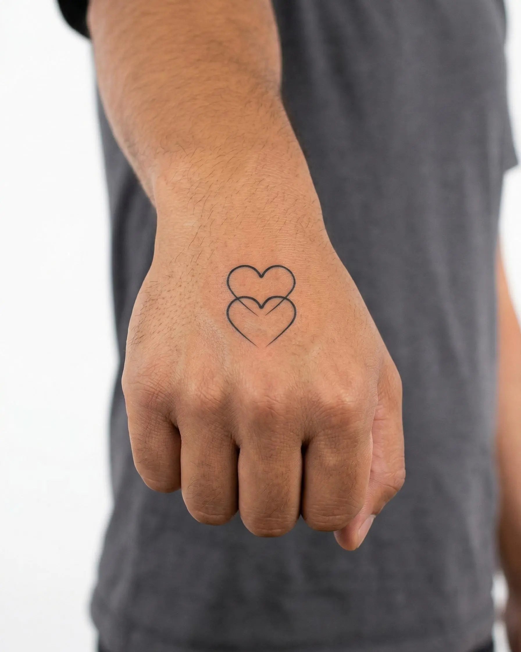 Tatuaggio semi-permanente INKON Double Hearts applicato su un uomo – design 2 x 2 in (5x5cm), aspetto realistico dell'inchiostro, dura 10 giorni