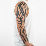 Tatuaggio semi-permanente INKON Flowing Tribal Sleeve applicato su un uomo – design 8 x 20 in (20x50cm), aspetto realistico dell'inchiostro, dura 10 giorni