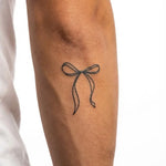 Tatuaggio semi-permanente INKON Ribbon Bow applicato su un uomo – design 2 x 2 in (5x5cm), aspetto realistico dell'inchiostro, dura 10 giorni