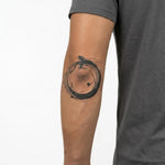Tatuaggio semi-permanente INKON Serpente Ouroboros applicato su un uomo – design 4 x 4 in (9x9cm), aspetto realistico dell'inchiostro, dura 10 giorni