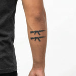 Tatuaggio semi-permanente INKON Assault Rifle Duo applicato su un uomo – design 3 x 4 in (6x11cm), aspetto realistico dell'inchiostro, dura 10 giorni