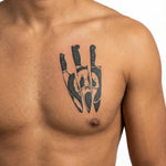 Tatuaggio semi-permanente INKON Ghost Face & Knives applicato su un uomo – design 4 x 4 in (9x9cm), aspetto realistico dell'inchiostro, dura 10 giorni