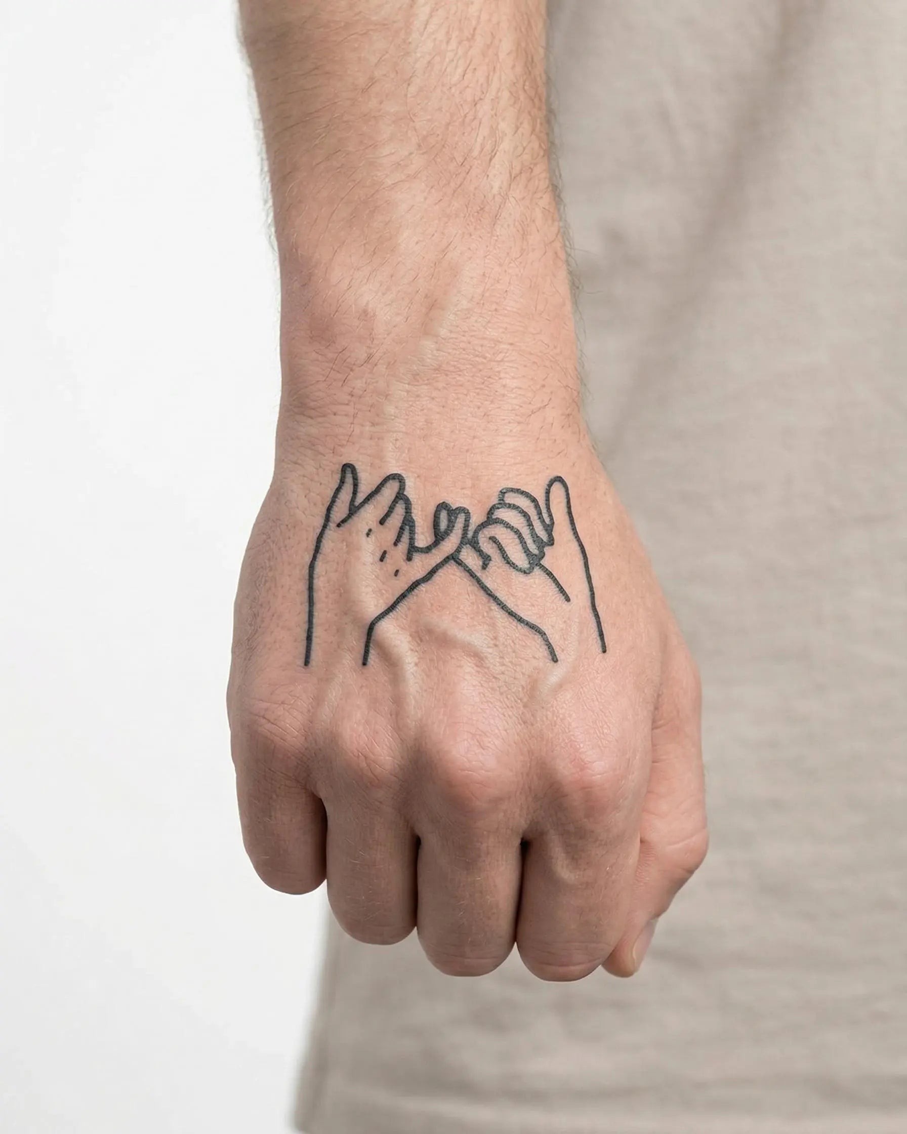 Tatuaggio semi-permanente INKON Pinky Promise 2 applicato su un uomo – design 2 x 2 in (5x5cm), aspetto realistico dell'inchiostro, dura 10 giorni